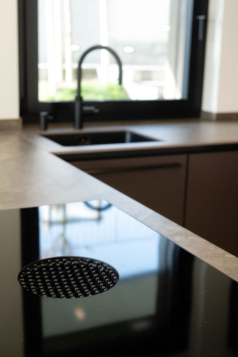 kitchen with black countertop, sink, faucet, view from window