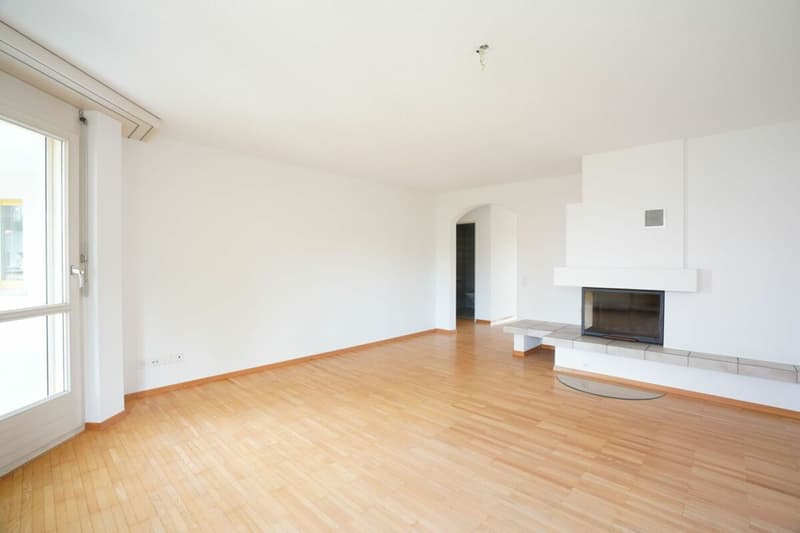 Wohnzimmer mit Cheminée und Balkonzugang