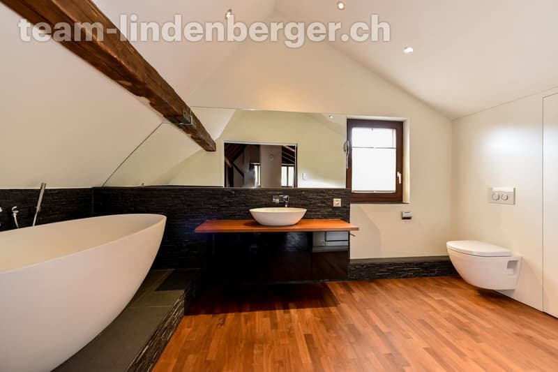 Zweites Badezimmer mit freistehender Badewanne und Einbauschränken