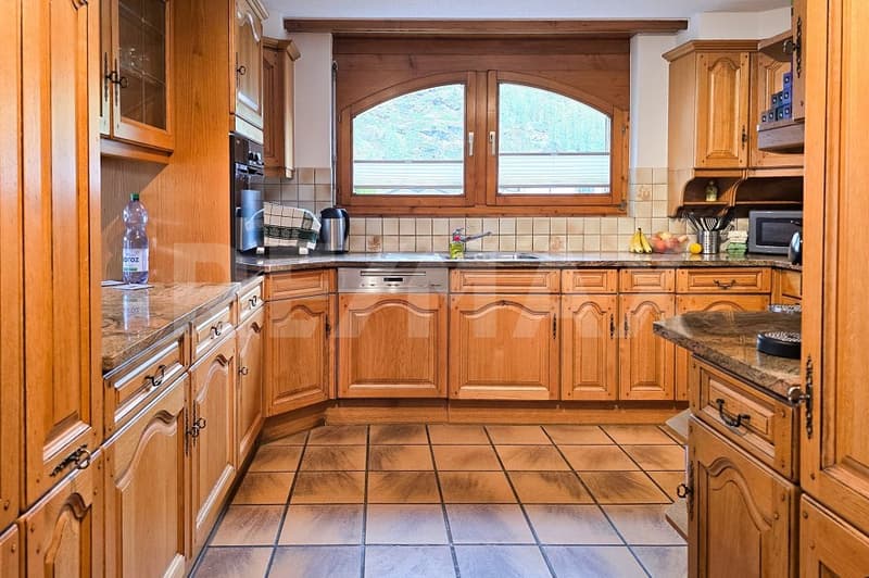 kitchen with wooden cabinets, granite countertops, dishwasher, sink, microwave, coffee machine, window