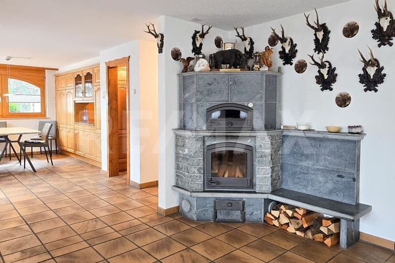 Fireplace, tiled floor, dining table, chairs, wooden cabinets, deer heads on wall