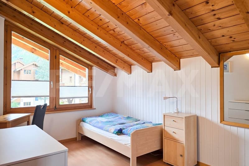 bedroom with bed, desk, chair, lamp, wooden ceiling, window, wooden floor