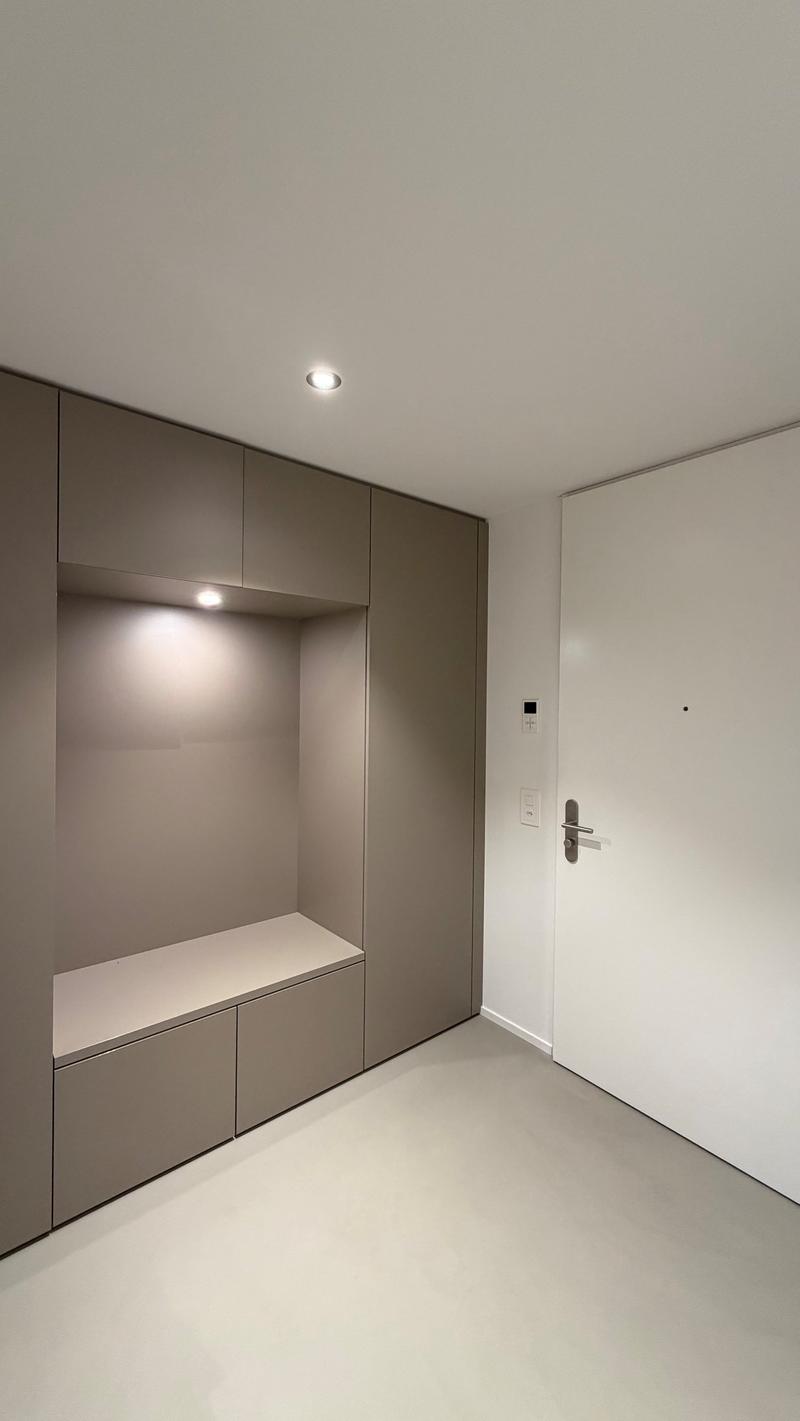 grey wall-mounted cabinets, integrated lighting, white floor, white door, power outlets