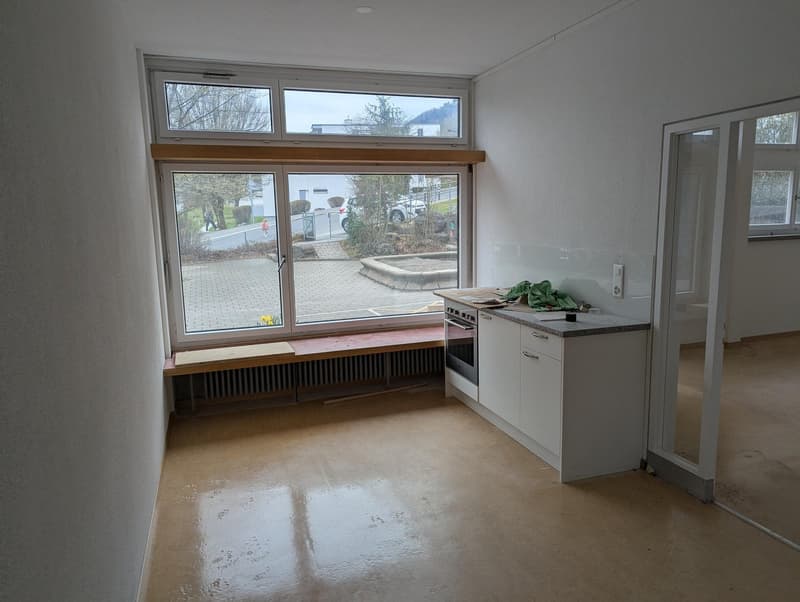 empty room, large window, wooden bench, white kitchen, radiator