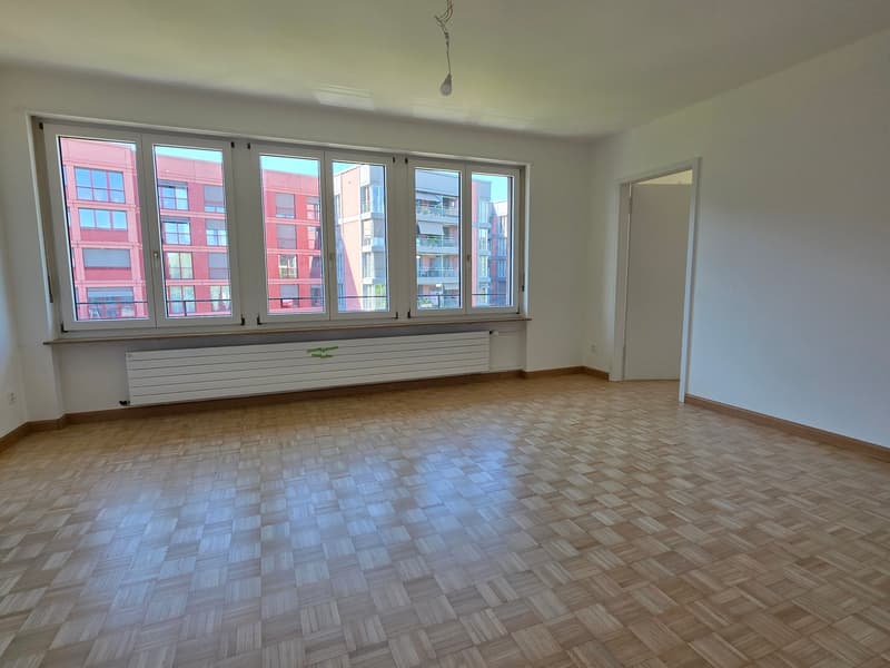 empty room, wooden parquet floor, large windows, white walls, radiator
