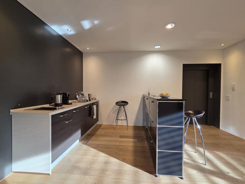 Wooden cabinets, white countertops, modern kitchen island, bar stools, modern fixtures