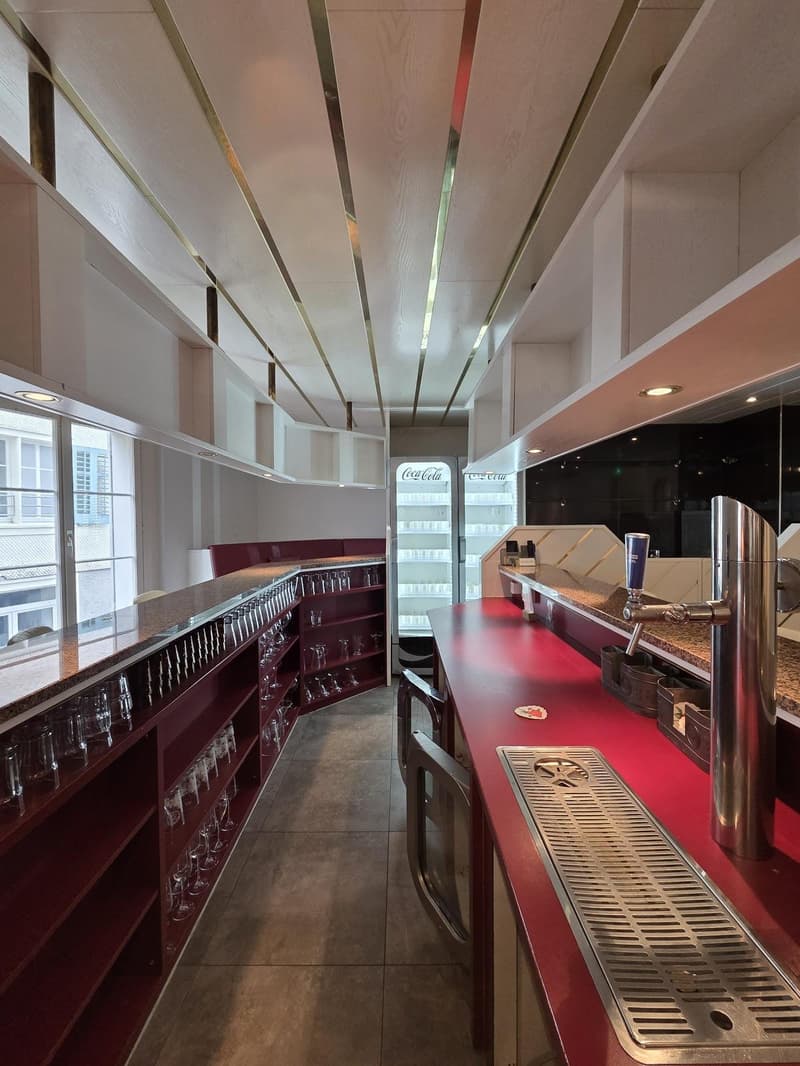 empty room, red counter, shelves with wine glasses, refrigerator, large windows