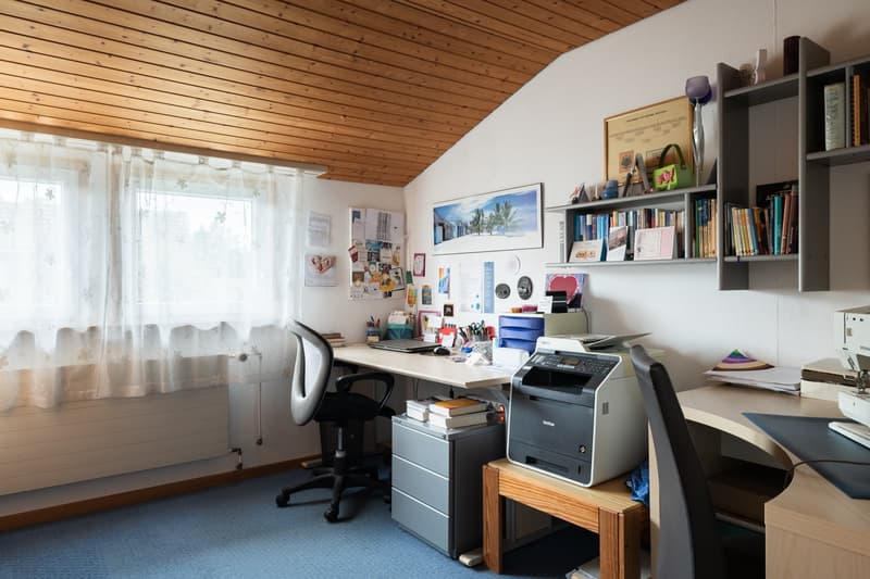 room with desk, printer, shelf with books, cabinet, chair, radiator, printer, window with curtains