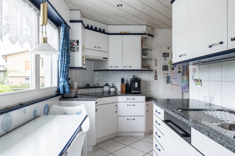 modern kitchen with granite countertops, white cabinets, built-in oven, induction stove, dishwasher, fridge, coffee maker, granite countertops