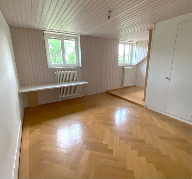 empty room, wooden floor, white walls, two windows, white radiators, white bench, white wardrobe