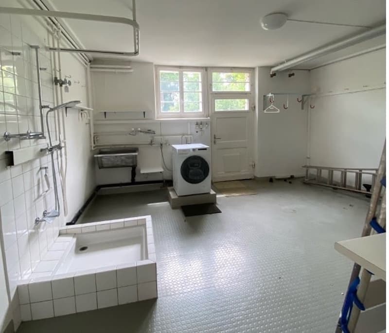 laundry room with washing machine, sink, shower, and storage