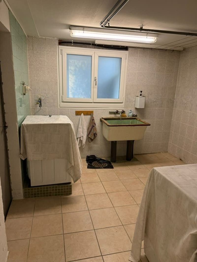 Bathroom with washing machine, sink, and window