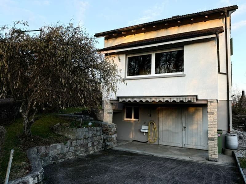 Two story house, white exterior, garage, two driveways, small trees