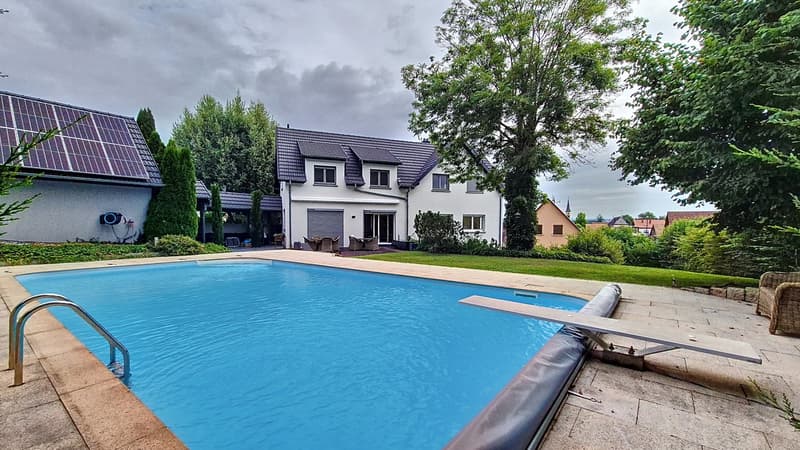 Modern house, swimming pool, well-kept garden, solar panels on the roof
