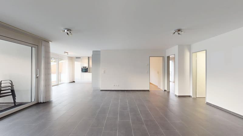 Spacious hallway with sliding glass doors, tiled flooring, two ceiling lights, opening to different rooms