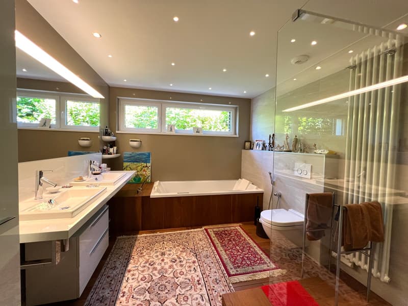 double sink, wooden bathtub, walk-in shower, white tiles, wooden flooring, glass doors, window, radiator, decorative items