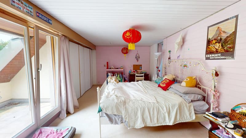 Bedroom with bed, sliding glass doors, large window, pink walls, red lanterns, clothes rack, table, lamp