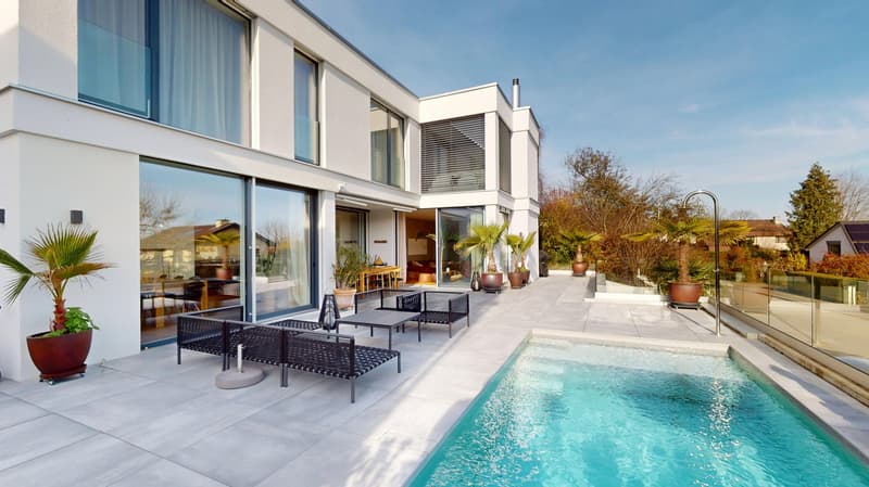 Modern white house with glass walls, patio, swimming pool, glass fencing, potted plants