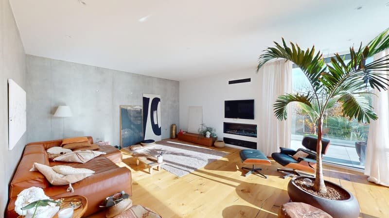 large living room, hardwood floors, gray concrete walls, fireplace, white walls, television, rug, couch, armchair, coffee table, armchair, chair