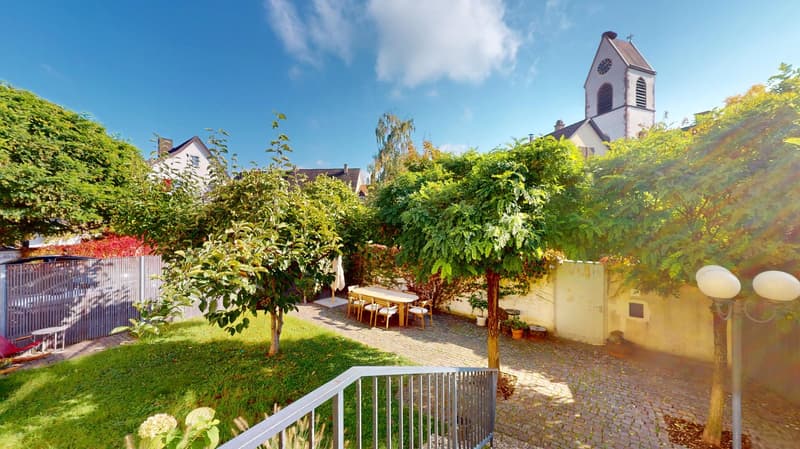 brick patio, outdoor dining table and chairs, trees, lawn, fenced area