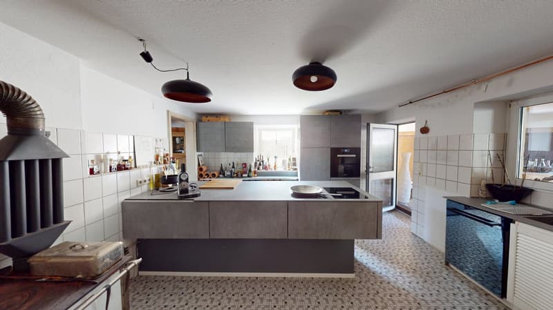 modern kitchen with island, countertop, central cooking stove, oven, dishwasher, kitchen cabinets, white tiles, lights, open door to another room, windows