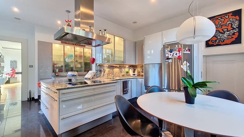 white kitchen with granite countertop, modern black chairs, stainless steel appliances, white dining table, pendant light