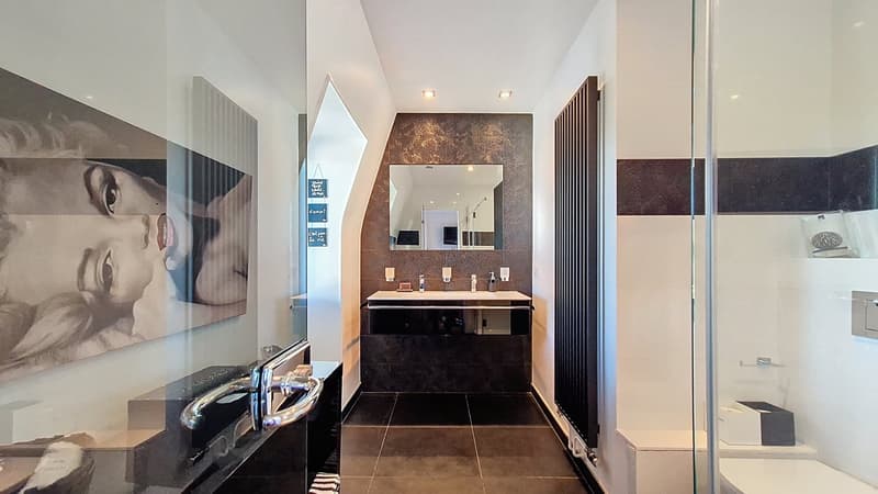 A bathroom with a glass door, sink, mirror, radiator, a frame and tiled floor.