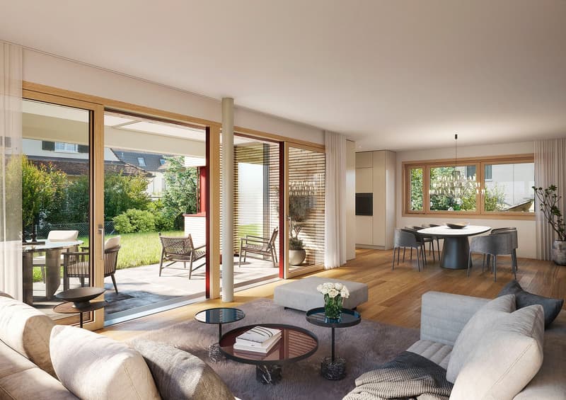 Living room with hardwood floors, large windows, sliding doors to terrace, round coffee tables, white sofa with pillows, chandeliers, large round dining table, plants, view of grass lawn and garden.