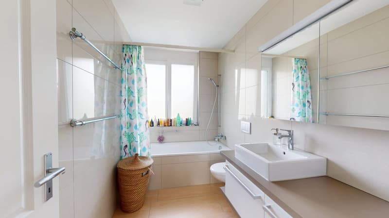 Bathroom with bathtub, sink, toilet, and shower curtain