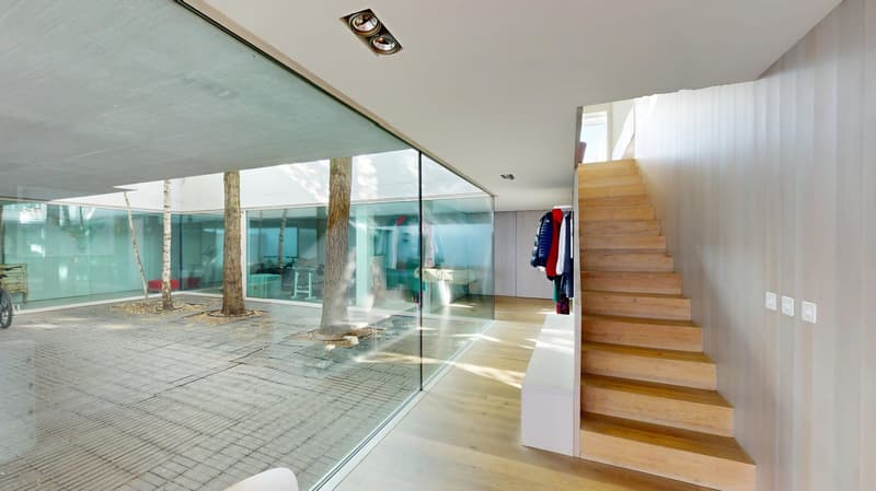 wooden floor, glass walls, wooden stairs, white walls, clothes hanging on the wall