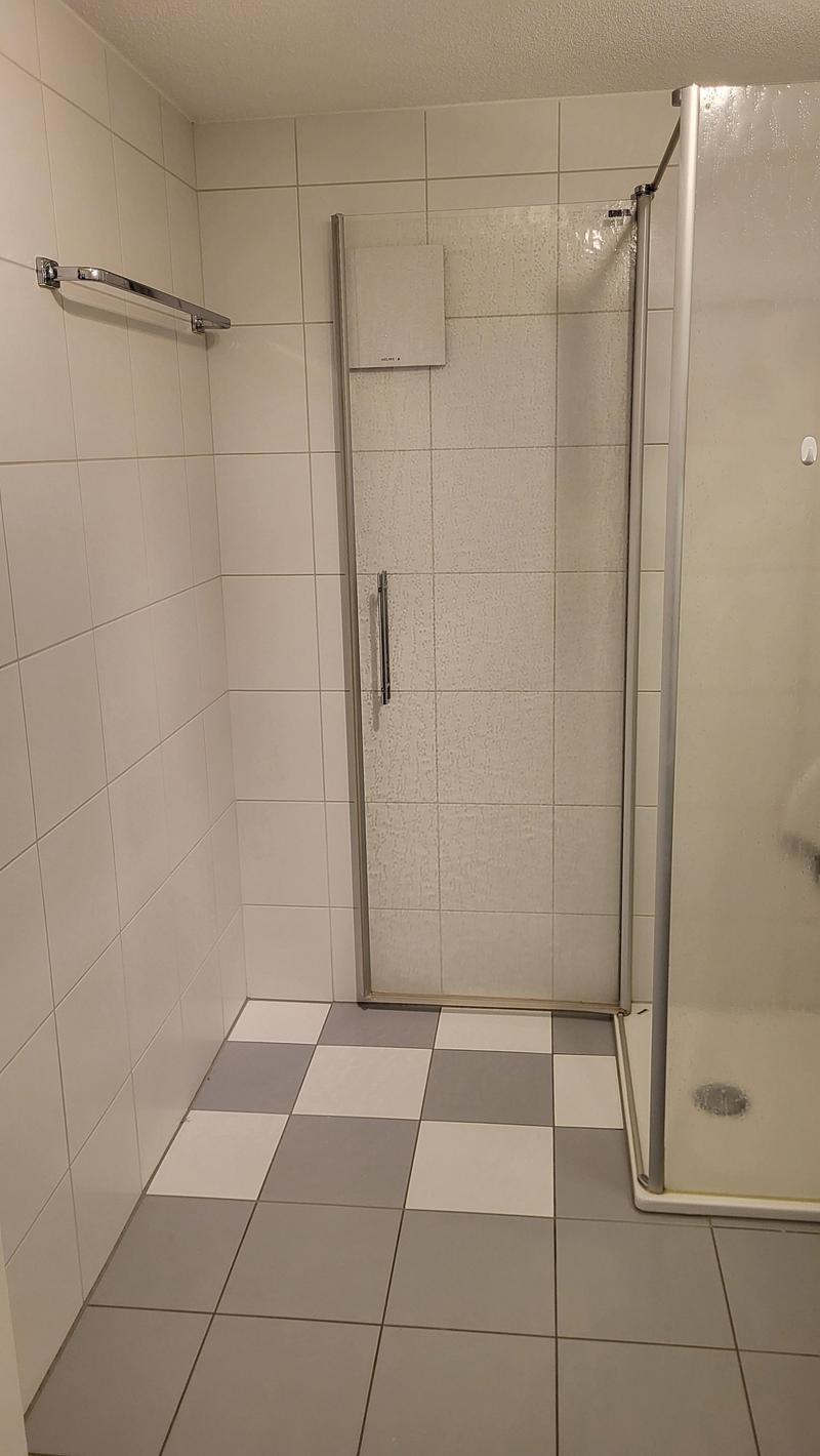 tiled floor, tiled walls, glass shower enclosure, towel rack