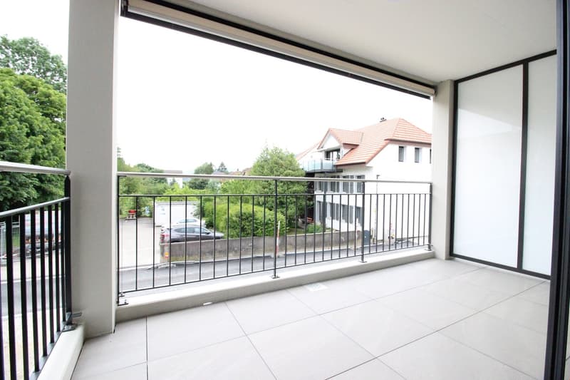 Balcony with railings, tiled floor, view of the street and trees