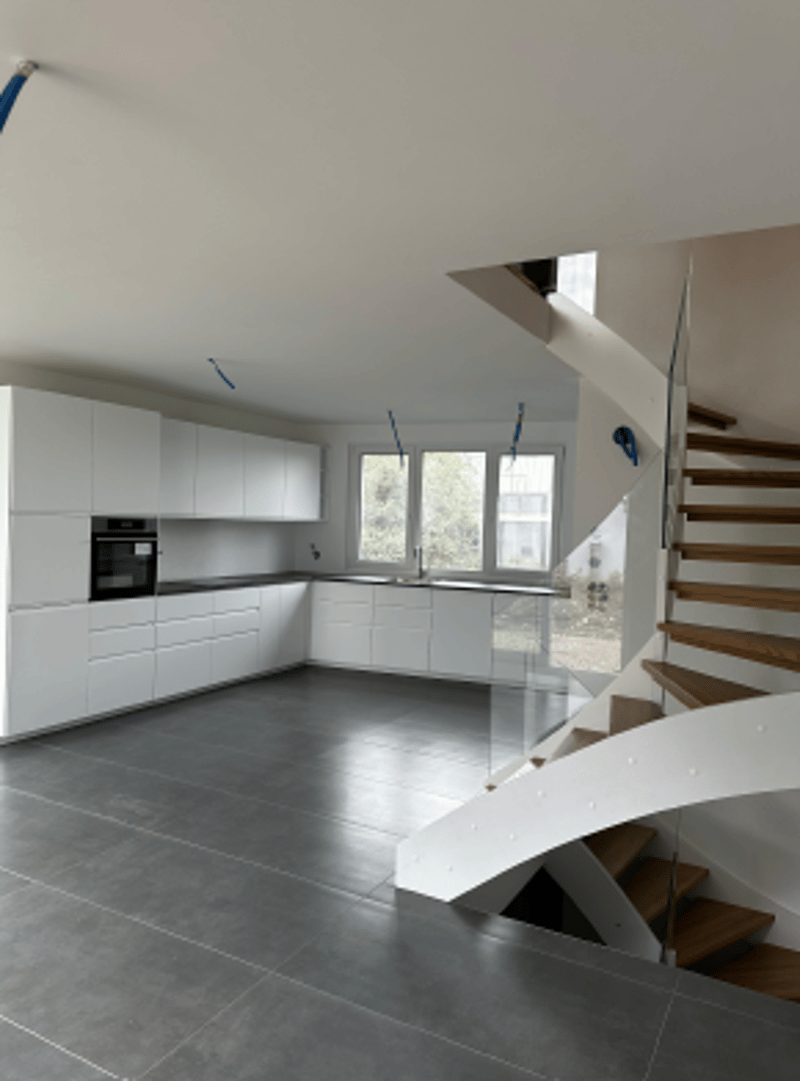 empty kitchen, white cabinets, modern staircase, gray tiles, open view