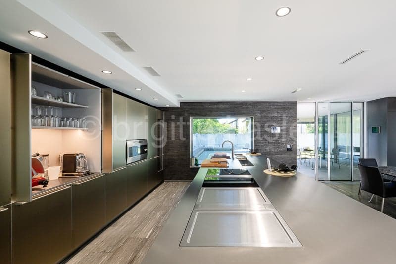 open plan kitchen with large island and counter, modern appliances, sliding doors