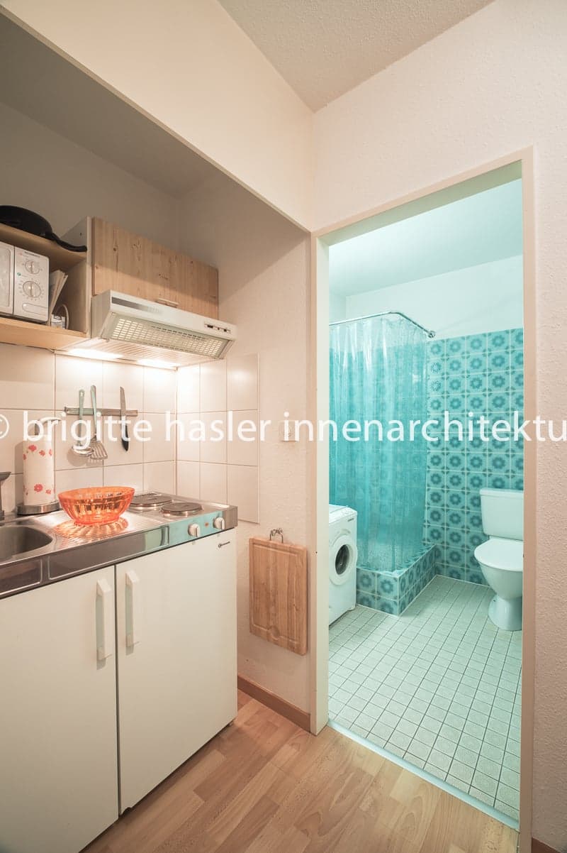 small kitchen with sink, stove, and microwave, small bathroom with toilet and shower