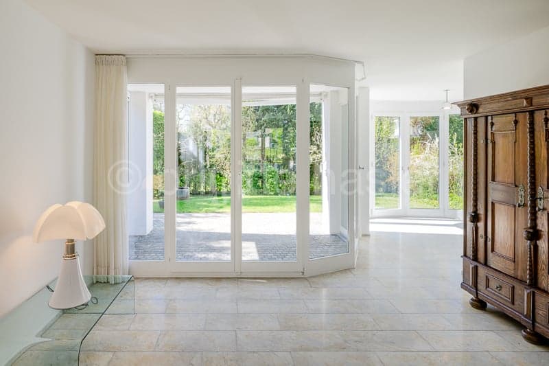 large glass doors, wooden cabinet, white tiled floor, lamp, glass table