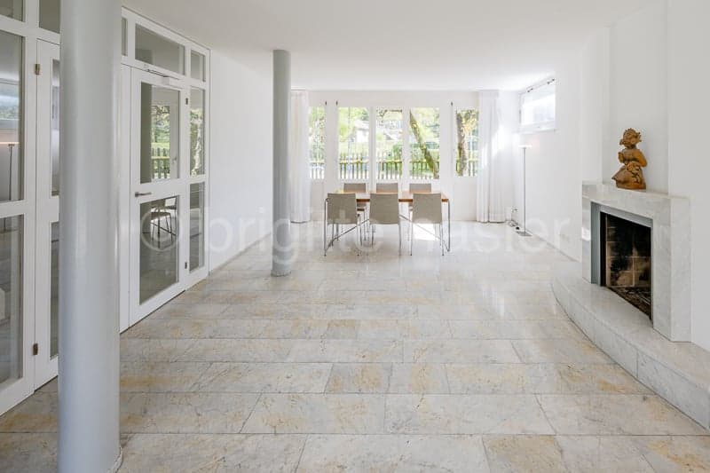 large room, marble floor, white walls, fireplace, dining table, chairs, glass doors, windows