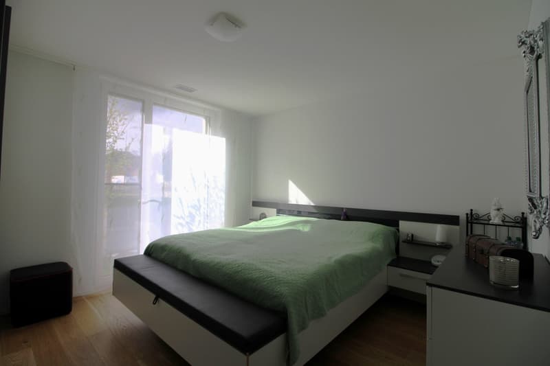 Bedroom with bed, nightstands, mirror, and window with curtains