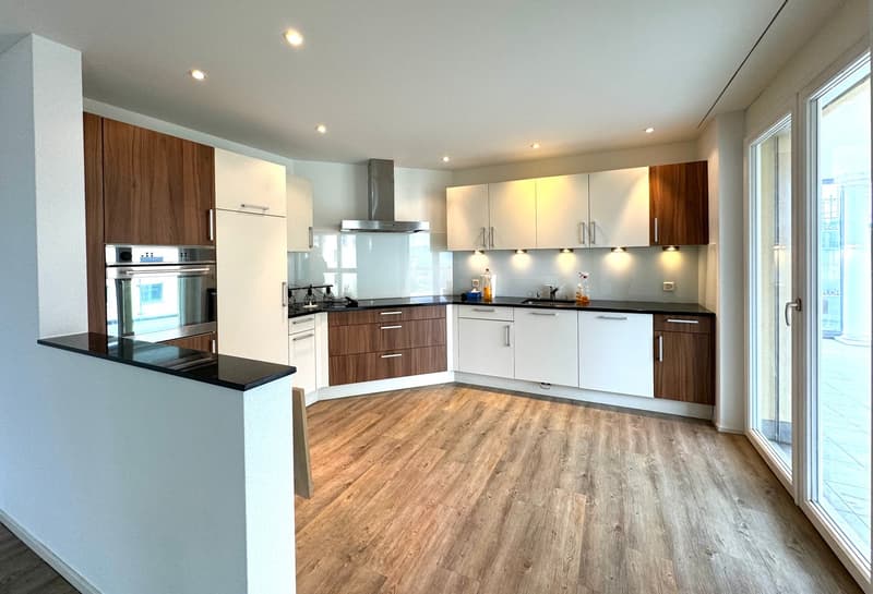 modern kitchen with wooden cupboards, stainless steel appliances, tiled floors, glass sliding door