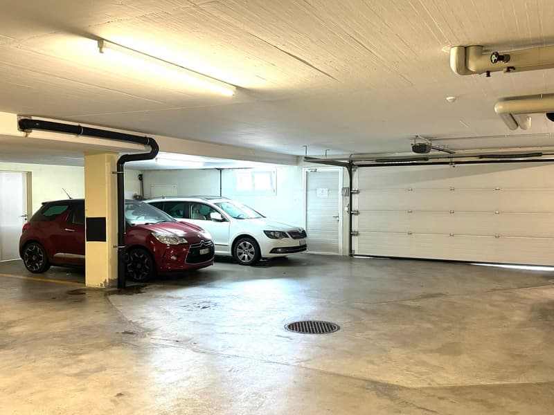 underground garage, 2 parked cars, security camera, drainage cover