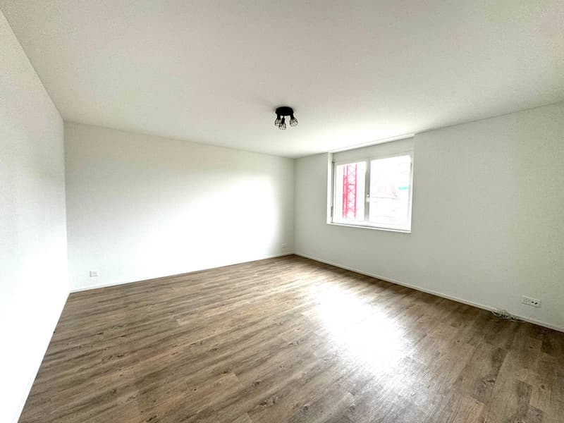 empty room, white walls, wooden floor, single window, recessed ceiling lights