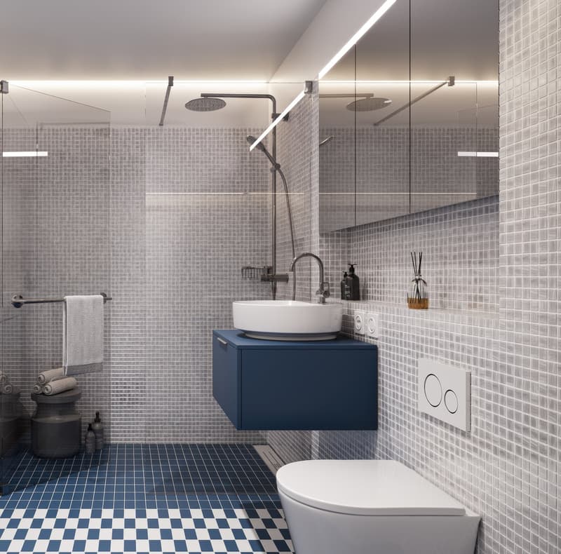 Modern bathroom with blue and white checkered floor, glass shower enclosure, white sink, blue cabinet, white toilet, wall-mounted towel rack, and small shelf with decorative items.