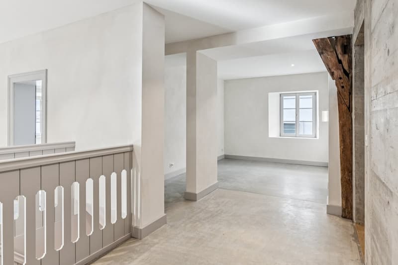 Empty room, white walls, concrete floor, wooden beam, window