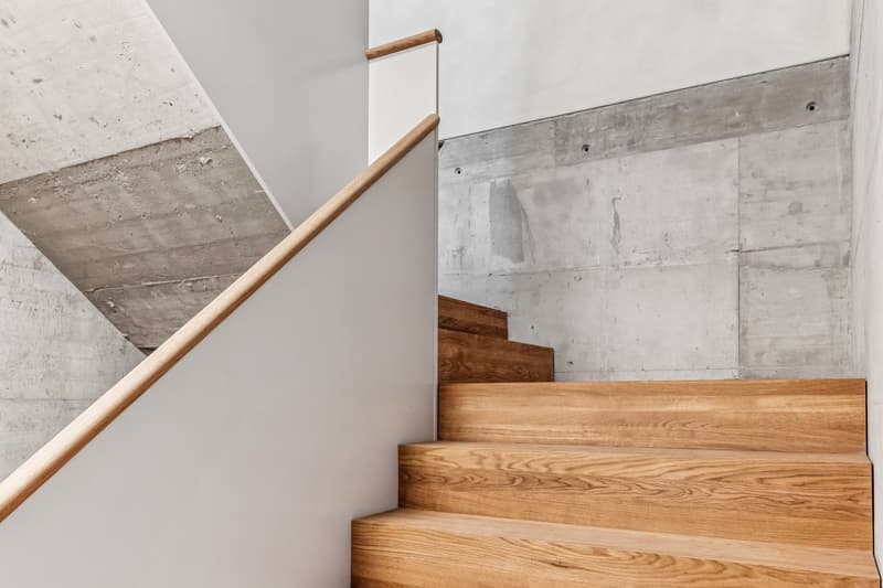 wooden stairs, white wall, concrete ceiling