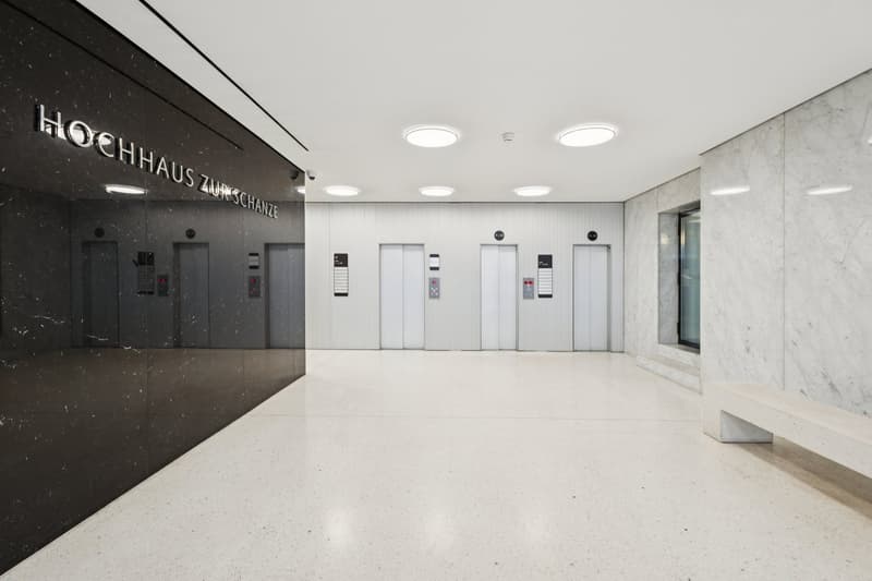 modern building, marble walls, white floors, elevator shafts, surveillance camera