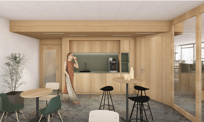 modern kitchen area with wooden cabinets, green countertop, sink, coffee machine, and a small table with stools