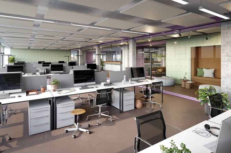 open plan office with many desks and office chairs, potted plants, monitors, and storage units