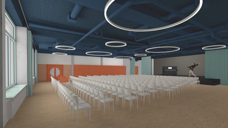 Auditorium with rows of white chairs, blue ceiling with circular lighting, orange partitions, a person playing piano, and windows with green sills.