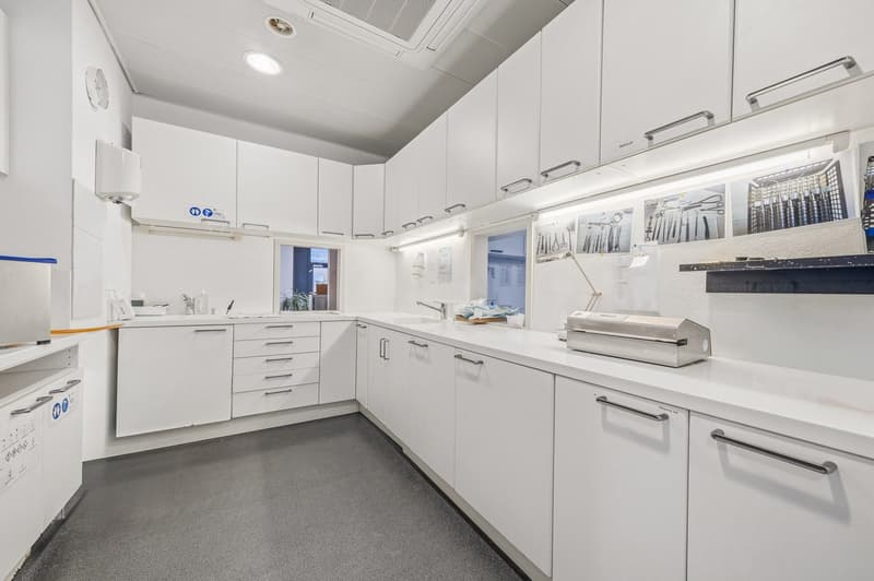 modern kitchen with white cabinets, countertops, and appliances, ceiling lights, and a sink