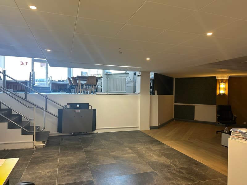 Open room with staircase, modern design, black and gray tiled floor, white walls, visible office equipment, open view to outside